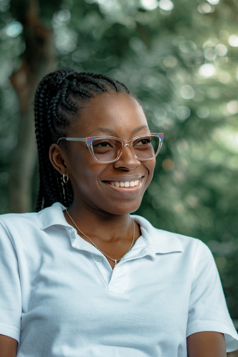 Smiling woman wearing glasses in nature.